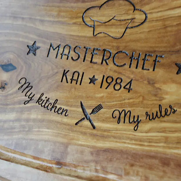 Schneide- und Tranchierbrett in verschiedenen Größen und Formen mit dem Gravurmotiv "MASTERCHEF - My kitchen - My rules" mit personalisierten Namen und einer stilisierten Kochmütze