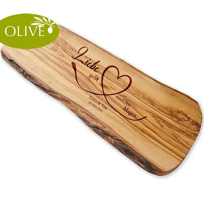 Motiv LIEBE GEHT DURCH DEN MAGEN auf ein Olivenholz glattes Schneidebrett graviert mit personalisierten Namen und Datum und einem geschwungenem Herz