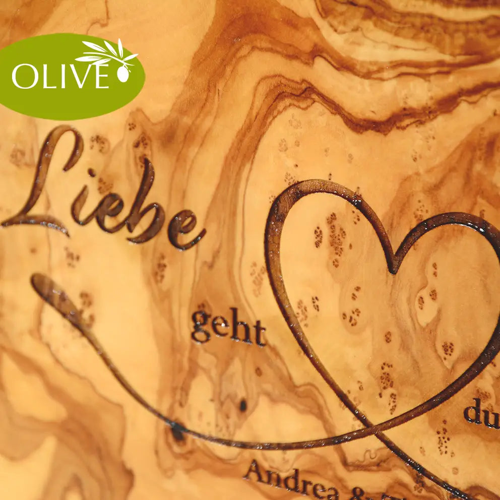 Motiv LIEBE GEHT DURCH DEN MAGEN auf ein Olivenholz glattes Schneidebrett graviert mit personalisierten Namen und Datum und einem geschwungenem Herz