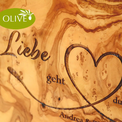 Motiv LIEBE GEHT DURCH DEN MAGEN auf ein Olivenholz glattes Schneidebrett graviert mit personalisierten Namen und Datum und einem geschwungenem Herz