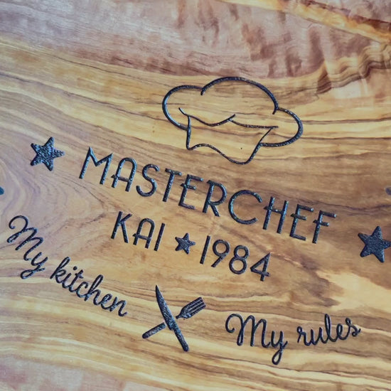 Schneide- und Tranchierbrett in verschiedenen Größen und Formen mit dem Gravurmotiv "MASTERCHEF - My kitchen - My rules" mit personalisierten Namen und einer stilisierten Kochmütze